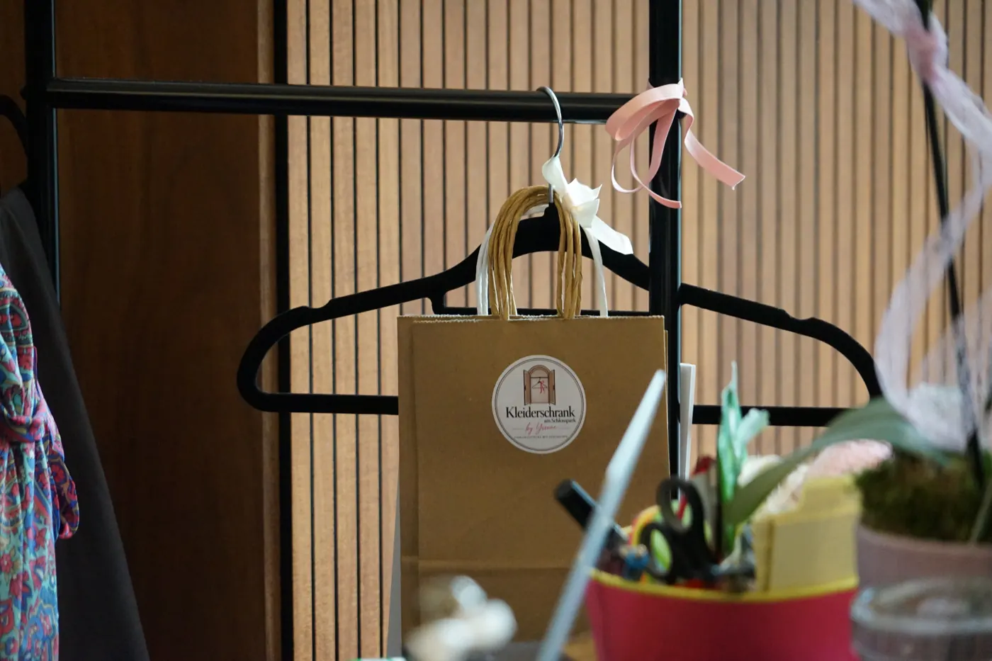 Papiertüte mit Kleiderschrank-Logo am Bügel