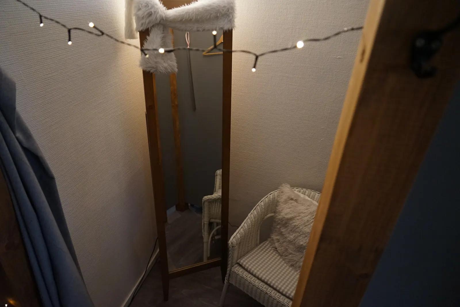 Umkleide mit Lichterkette, Spiegel und Korbsessel